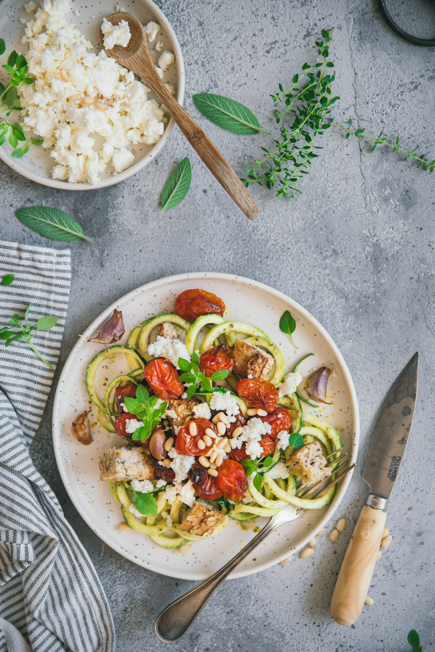 Zucchini spaghetti with pesto, roasted tomatoes and feta cheese