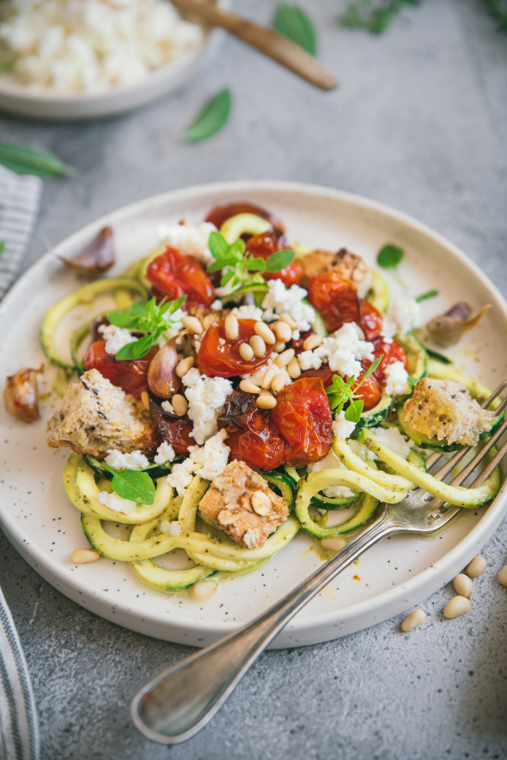 Zucchini spaghetti with pesto, roasted tomatoes and feta cheese